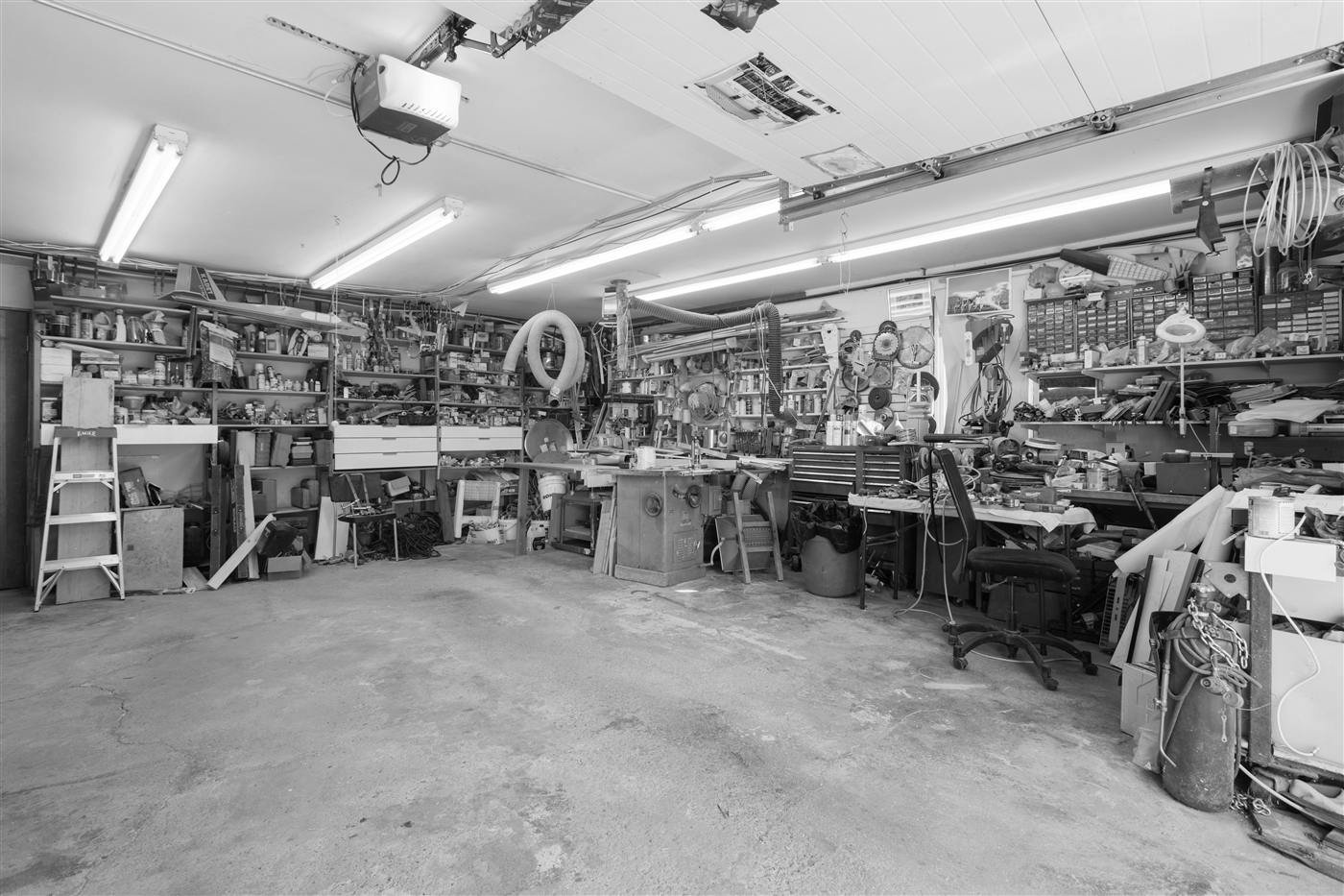 A garage workshop with every shelf and bench overflowing